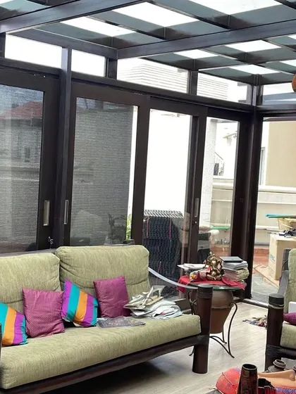 A duplicate image of the Ghana Teak sunroom, offering another angle of the comfortable seating arrangement and the seamless connection to the outdoors.