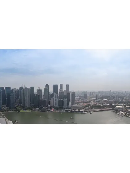 A wide panoramic shot of the Singapore skyline and Marina Bay, taken from a high vantage point during the day.