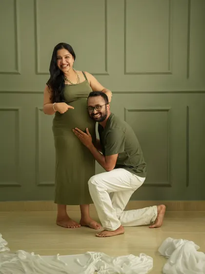 A fun and sweet pose! The father-to-be listens to the baby bump, creating a playful and heartwarming memory in the studio.