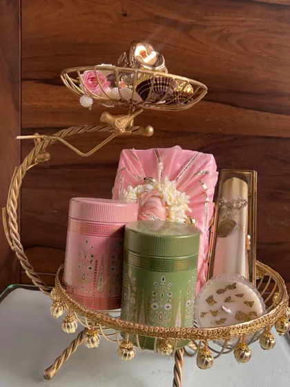 This is an example of a luxurious wedding favor arrangement. I use ornate golden stands to display a collection of gifts, including scented candles, gourmet teas, and sweets.
