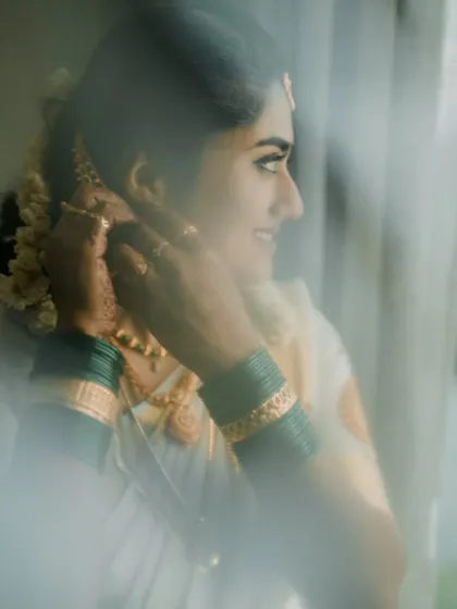 A candid "getting ready" shot of a bride putting on her earrings, a small but meaningful moment.