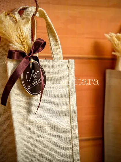 A close-up of the branded jute goodie bags. We finished each one with a custom tag and a rustic ribbon with dried wheat, ensuring even the giveaways were perfectly on-theme.