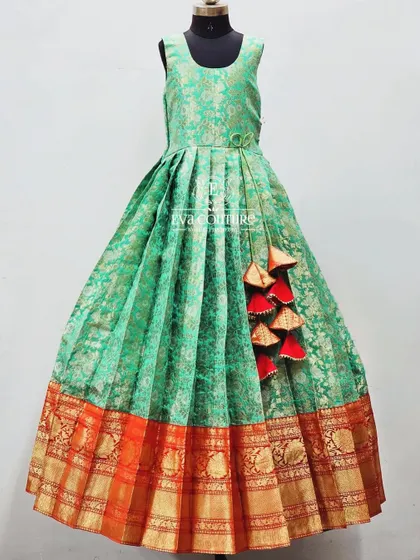 A simple and elegant floor-length gown made from a single piece of sea-green Banarasi silk. The dress has a traditional orange and gold zari border at the hem.