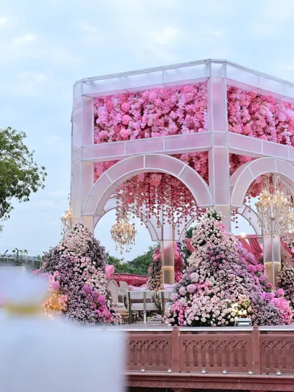 A closer look at the mandap's structure, where the upper portion is filled with a dense wall of pink flowers, creating a stunning visual impact.