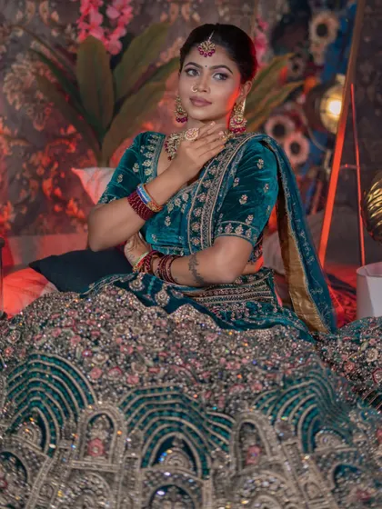 A close-up of the beautiful details on the blouse and the rich color of the makeup.