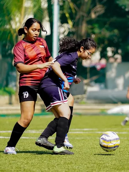 A physical but fair challenge for the ball between two determined players, highlighting the competitive spirit of our girls' tournaments.