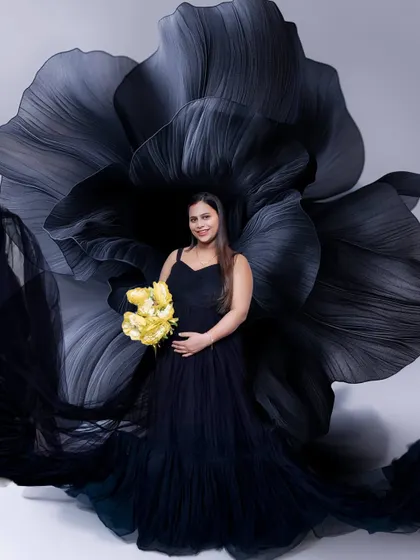 A classic black gown paired with a dramatic black flower backdrop for a touch of modern elegance. The pop of yellow from the flowers adds a beautiful, hopeful contrast.
