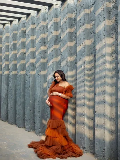 Our Bronze gown looks stunning against this modern, architectural backdrop. The play of light and shadow adds a dramatic effect.
