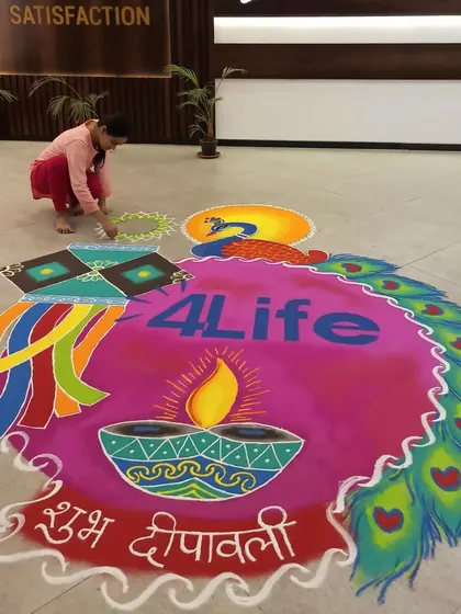Here I am, putting the finishing touches on a large corporate rangoli. This shows the scale of my on-site work and the freehand process I use to create every detail, from the logo to the intricate peacock feathers.