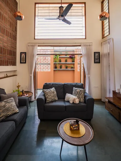 A cozy seating area that opens into a small, private courtyard. This is a perfect example of how we integrate small outdoor pockets to enhance natural light and ventilation in urban homes.