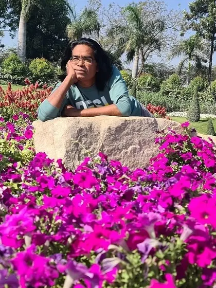 Pausing for a moment of reflection on a rock amidst a sea of flowers. Nature is my biggest teacher and my place of peace.
