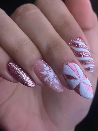 A winter wonderland on your nails. This festive set features rose gold glitter, a delicate hand-painted snowflake, and a candy cane stripe design. It’s a chic and sparkly way to celebrate the season.
