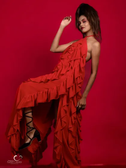A dynamic and expressive pose in a ruffled red gown. The movement and energy in this shot are palpable, creating a sense of high-fashion drama.