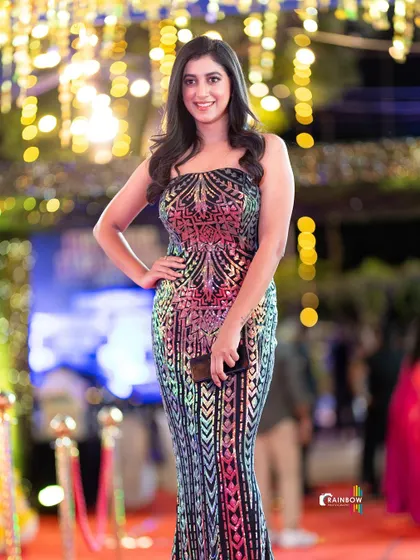 A guest posing against the beautifully lit background of the event.
