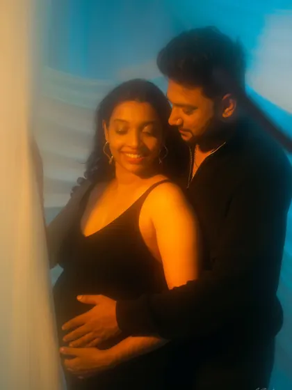 An intimate and artistic couple's portrait with soft focus and creative lighting, capturing a tender moment between the parents-to-be.