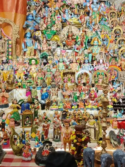 A massive, vibrant display of dolls representing various gods, goddesses, and celestial beings. This is the 'golu' or 'bombe habba' tradition, presented on a grand scale.