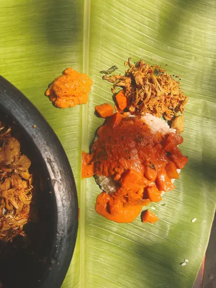 A serving of the Vishu Sadya on a banana leaf. The combination of red rice with Jackfruit Thoran, Pumpkin Pulinkari, and Mambazha Pachadi is a perfect representation of the season's harvest.