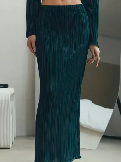 A view of the pleated maxi skirt from the two-piece set, showing its full length and the beautiful texture of the fabric.