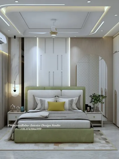 This bedroom at Neelkanth, Thane, uses a soft green for the bed, creating a calm and refreshing atmosphere. The headboard wall features a mix of textures and a large, arched mirror.