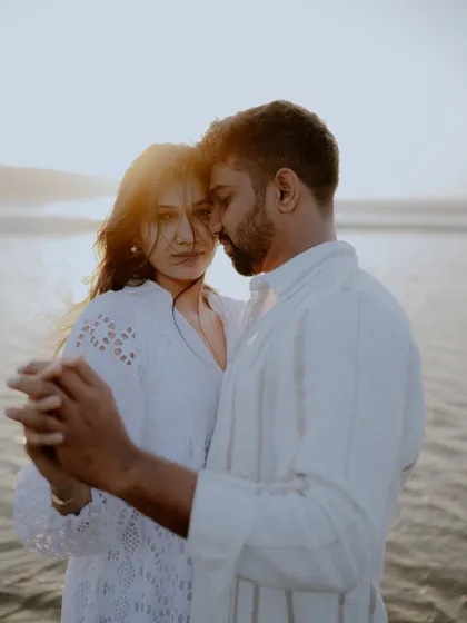 A tender moment of the couple dancing on the beach at sunset. The warm light and their close hold create a dreamy and cinematic feel.