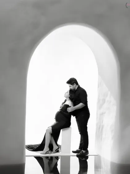 Sometimes, the most powerful stories are told in black and white. This intimate couple portrait, framed by a simple archway, focuses purely on the connection and anticipation between two people about to become parents.