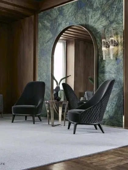 This design showcases a dramatic waiting or living area with high-backed, quilted lounge chairs. The arched mirror and wood-paneled walls create a sense of grandeur and depth.