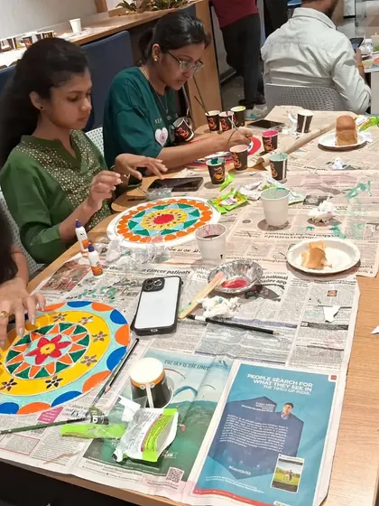 This view of the workshop table shows multiple Lippan art pieces in progress. It's fascinating to see how different individuals interpret the same project with their own unique color palettes.