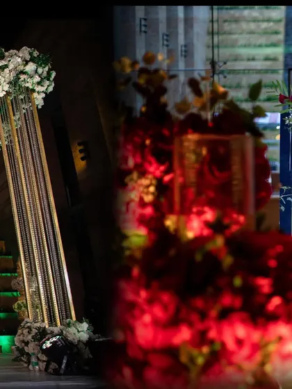 A glimpse of two different decor styles side by side. On the left, an elegant white floral stage, and on the right, a bold red floral entrance for a Sangeet, showing my versatility.