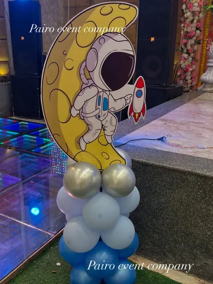 A custom prop for our space-themed party. This standalone piece features an astronaut on the moon, supported by a base of balloons, adding a great photo opportunity away from the main stage.
