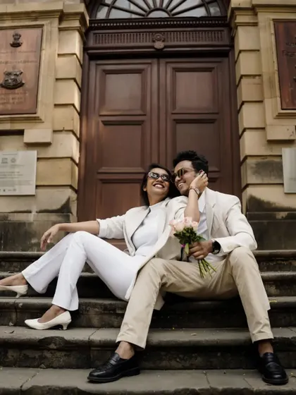 Sharing a laugh on the steps of a historic building. It’s a beautiful blend of candid happiness and sophisticated style.