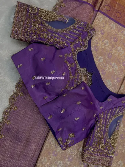 A purple blouse with delicate embroidery and a sheer net panel on the sleeves.