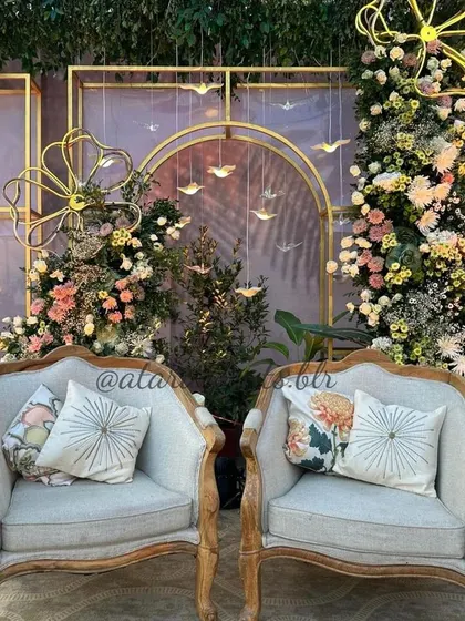 Another view of the elegant baby shower stage, showing the beautiful vintage-style chairs and the lush floral arrangements that create a romantic and whimsical setting.