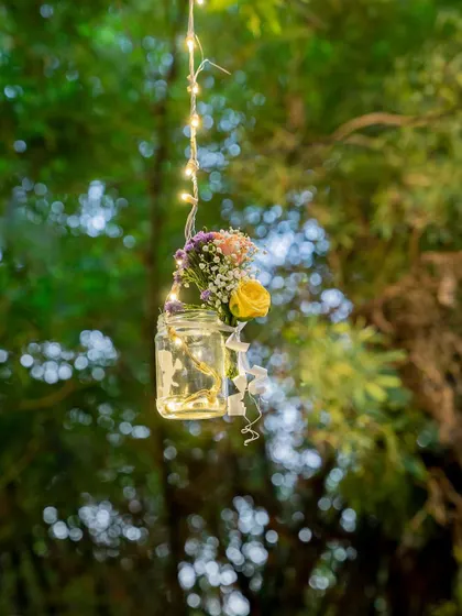 A duplicate of image 13, showcasing the charming hanging jar with flowers and lights.