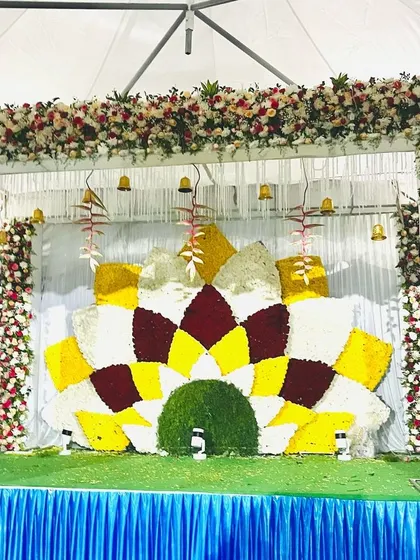 A large, semi-circular floral backdrop made of colorful flowers. This design is perfect for an outdoor stage or a large hall, creating a vibrant and impressive focal point.