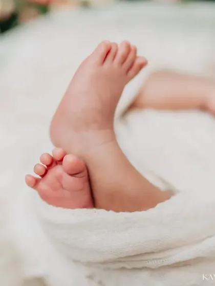 A beautifully composed shot of newborn feet, with the baby's face softly blurred in the background. This artistic focus draws all attention to just how small and perfect those feet are.