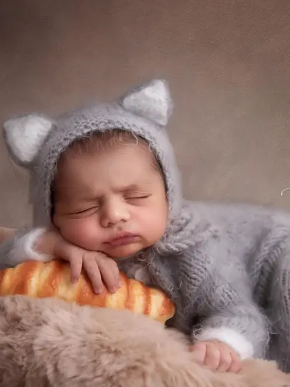 A close-up of our little baker, looking so peaceful on his croissant pillow. The soft, warm lighting and textures make this shot extra cozy.