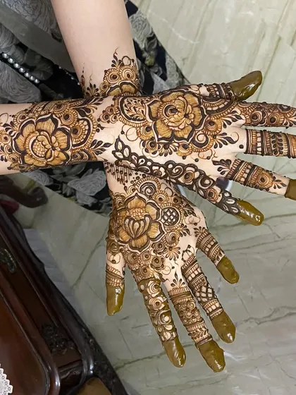 A beautiful pose showcasing both the front and back of the hands with floral henna.