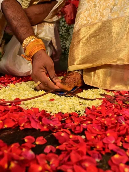 Another angle of the Saptapadi ritual, with the bride's henna-stained foot on a bed of flowers.