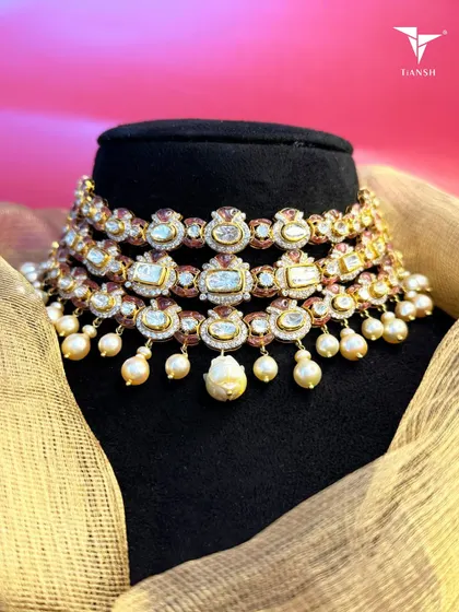 True beauty lies in the details. This three tier Kundan choker merges centuries old craftsmanship with a fresh silhouette, while the delicate pearl drops add a final touch of enchantment and grace.