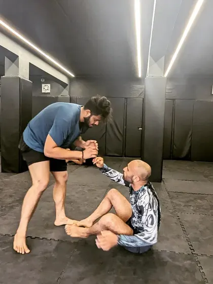 Sportsmanship and respect are core to our values. Here, two training partners help each other up after a tough grappling roll. We are competitors, but we are also a team.