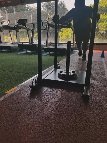 A client pushes the sled down our track, a key component of our high-intensity conditioning workouts.