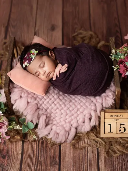 A different angle of the sleeping baby in the purple-themed setup.