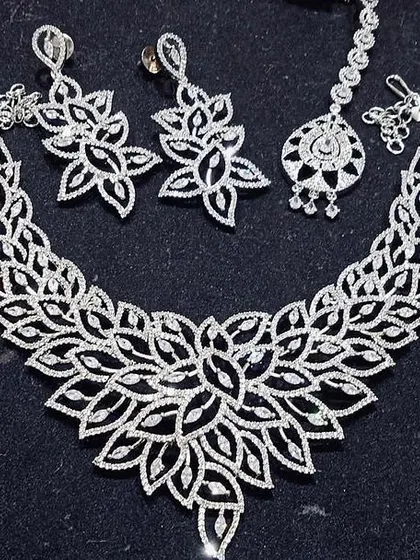 A stunning floral-design necklace set made entirely of sparkling CZ stones. This rental includes the necklace, earrings, and a matching maang tikka.