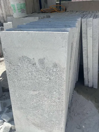 A stack of precisely cut stone slabs, ready for paving.