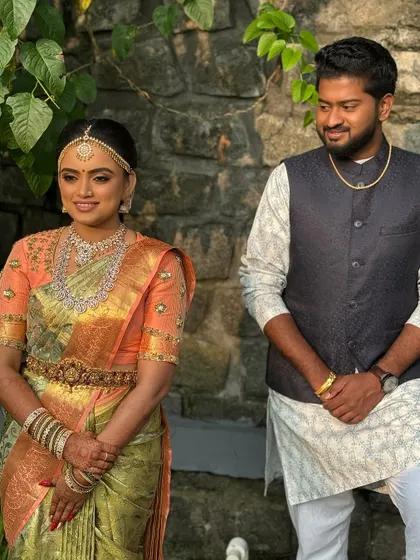 A lovely portrait of the bride and groom. Her makeup is designed to look fresh and natural even in outdoor lighting, complementing her beautiful silk saree and his classic attire.