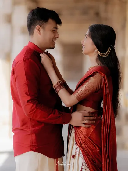 A playful moment where the bride-to-be adjusts her partner's collar, showing their natural and comfortable dynamic.