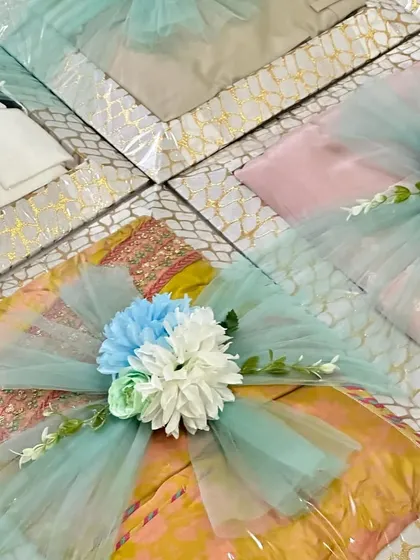 A closer look at the engagement gift trays, showing the beautiful combination of patterned boxes, sea-green tulle, and floral accents.