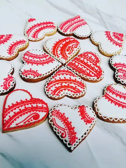 I love making cookies for Valentine's Day. These heart-shaped sugar cookies are decorated with delicate, lace-like patterns in red royal icing on a crisp white background. They are almost too pretty to eat.