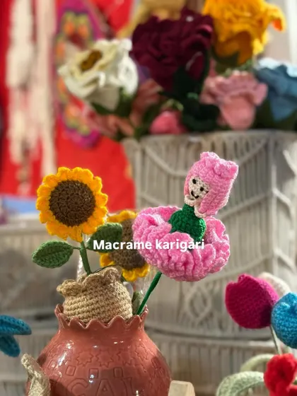 A whimsical combination of our crochet flower creations. Here you can see a sunflower mini pot next to one of our unique carnation dolls, where the flower's petals form a dress for a tiny doll.