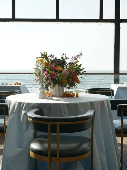 A simple, elegant table setting with an ocean view. The focus here is on the stunning natural backdrop, complemented by clean and understated decor.